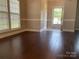 Bright living room with hardwood floors, base molding, and view to the entryway at 11622 Lioness St, Charlotte, NC 28273