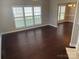 Spacious living area with dark hardwood floors, three windows, and view into dining room at 11622 Lioness St, Charlotte, NC 28273