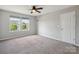 Neutral bedroom boasts carpet flooring, a ceiling fan, a window overlooking trees, and a closet door at 1175 Valley St # 111, Statesville, NC 28677