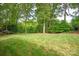 Lush backyard with mature trees and manicured lawn, offering a private and peaceful outdoor retreat at 12048 Royal Portrush Dr, Charlotte, NC 28277