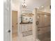 Bathroom showing beautiful marble counters, white cabinets, and tiled glass shower at 12048 Royal Portrush Dr, Charlotte, NC 28277