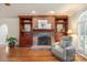 Elegant living room offering hardwood flooring, a brick fireplace, built-in shelves, and plantation shutters at 12048 Royal Portrush Dr, Charlotte, NC 28277