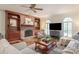 Inviting living room featuring hardwood floors, a brick fireplace, built-in shelving, and a plush sofa at 12048 Royal Portrush Dr, Charlotte, NC 28277