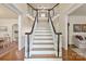 Elegant staircase with dark wood railings and white risers creates a grand entrance at 12048 Royal Portrush Dr, Charlotte, NC 28277