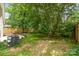 Spacious backyard featuring lush greenery, shade trees, and a wood fence for privacy at 1208 Tarrington Ave, Charlotte, NC 28205