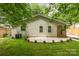 Well-maintained backyard with grass, landscaping, patio, and the exterior of the home at 1208 Tarrington Ave, Charlotte, NC 28205