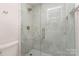 Modern bathroom with a frameless glass shower enclosed with marble-style tile at 1208 Tarrington Ave, Charlotte, NC 28205