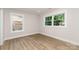 Bright, empty bedroom with neutral walls, laminate floors, and two large windows at 1208 Tarrington Ave, Charlotte, NC 28205