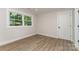 Bedroom with neutral walls, wood-look floors, and a view of backyard trees at 1208 Tarrington Ave, Charlotte, NC 28205