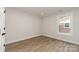 Empty bedroom with wood floors, bright window, and neutral wall paint at 1208 Tarrington Ave, Charlotte, NC 28205