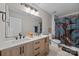 Stylish bathroom with a double vanity, designer lighting, and a shower-tub combination with a decorative curtain at 13315 Hunting Birds Ln, Charlotte, NC 28278