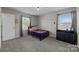 Cozy bedroom with carpet, black metal bed frame, windows with curtains, and a black dresser at 13315 Hunting Birds Ln, Charlotte, NC 28278