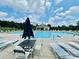 Community pool with lounge chairs, tables, and an umbrella for relaxing in the sun at 13315 Hunting Birds Ln, Charlotte, NC 28278
