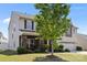 Charming two-story home with stone accents, a well-manicured lawn, and a welcoming covered front porch at 13315 Hunting Birds Ln, Charlotte, NC 28278