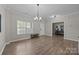 Welcoming living area features light-filled windows and hardwood floors, with a view into a functional office space at 13315 Hunting Birds Ln, Charlotte, NC 28278