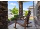 Inviting front porch with stone pillars and two wooden rocking chairs overlooking the neighborhood at 13315 Hunting Birds Ln, Charlotte, NC 28278