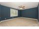 The bedroom features a neutral carpet and bright blue paint at 135 Canoe Pole Ln, Mooresville, NC 28117