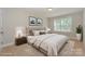 This bedroom features neutral colors, a plush bed, and natural light, creating a relaxing atmosphere at 135 Canoe Pole Ln, Mooresville, NC 28117