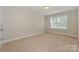 This bedroom is a clean slate with beige walls, neutral carpet, and a bright window to allow natural light at 135 Canoe Pole Ln, Mooresville, NC 28117