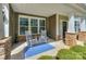 Inviting front porch featuring rocking chairs on a patterned rug, with stone pillar accents at 135 Canoe Pole Ln, Mooresville, NC 28117