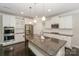 Bright kitchen features a large center island, stainless steel appliances, and white cabinetry at 135 Canoe Pole Ln, Mooresville, NC 28117