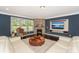 Cozy living room featuring a stacked stone fireplace, built-in TV, and ample natural light at 135 Canoe Pole Ln, Mooresville, NC 28117