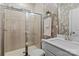 Well-lit bathroom featuring a glass-enclosed shower, stylish vanity, and elegant floral wallpaper at 154 Cotton Field Dr, Statesville, NC 28677