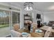 Bright dining area featuring a fireplace, modern lighting, and sliding glass doors to the screened in porch at 154 Cotton Field Dr, Statesville, NC 28677