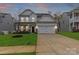 Charming two-story home features a well-manicured lawn, two-car garage, and inviting front porch at 154 Cotton Field Dr, Statesville, NC 28677