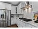 Bright kitchen with stainless steel appliances, white cabinets, and a modern range hood at 154 Cotton Field Dr, Statesville, NC 28677