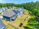 Drone shot capturing a spacious backyard with a patio, screened porch, and mature landscaping at 1540 Striped Bass Ln, Clover, SC 29710
