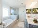 Bright bathroom featuring a bathtub, glass-enclosed shower, and double sink vanity at 1540 Striped Bass Ln, Clover, SC 29710