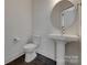 Clean powder room with a pedestal sink, mirror, and toilet at 1540 Striped Bass Ln, Clover, SC 29710