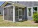 Relaxing screened-in porch extending from a gray home with lush green lawn and bushes at 1540 Striped Bass Ln, Clover, SC 29710