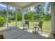 Inviting screened porch featuring two chairs with views of the lush backyard and greenery at 1540 Striped Bass Ln, Clover, SC 29710