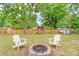 Large backyard with a fire pit, two Adirondack chairs, a playset, and a shed at 1724 Virginia St, Monroe, NC 28110