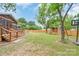 Expansive backyard with a deck, playset, firepit and mature trees, perfect for outdoor activities at 1724 Virginia St, Monroe, NC 28110