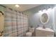 Bathroom featuring a shower with curtain, toilet, and a vanity with decorative plants and mirror at 1724 Virginia St, Monroe, NC 28110