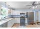 Well-lit kitchen featuring white cabinetry, modern appliances, and a dual basin sink beneath a sunlit window at 1724 Virginia St, Monroe, NC 28110