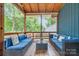 A blue cushioned seating area is highlighted in this screened-in porch at 1724 Virginia St, Monroe, NC 28110