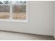 A bright bedroom featuring a window with view to a wooded backyard, carpet flooring, and white walls at 2031 Skyhawk Dr, York, SC 29745