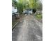 View of the cracked concrete driveway, storage shed, and backyard at 216 Maple St, Statesville, NC 28677
