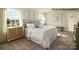Bright bedroom with a tufted headboard bed, side tables, and an adjacent closet at 222 Giant Oak Ave, Statesville, NC 28677