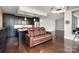 Open living space with a comfortable leather couch looking into the kitchen area at 222 S Caldwell St # 1909, Charlotte, NC 28202