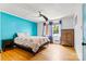 Relaxing bedroom offers hardwood floors, a ceiling fan, a floral comforter, and blue accent wall at 312 Rumple St, Troutman, NC 28166