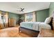 Comfortable bedroom features hardwood floors, a ceiling fan, natural light, and two wooden dressers at 312 Rumple St, Troutman, NC 28166