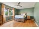 Spacious bedroom boasts hardwood floors, a ceiling fan, natural light, and two matching nightstands at 312 Rumple St, Troutman, NC 28166