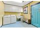 A laundry room with washer, dryer, cabinets, and blue trim around the bright yellow walls at 312 Rumple St, Troutman, NC 28166