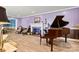 Stylish living room featuring a grand piano, fireplace, and hardwood floors, perfect for entertaining at 312 Rumple St, Troutman, NC 28166