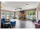 Spacious living room with brick fireplace, large windows, tiled floor, and access to the outdoor pool at 312 Rumple St, Troutman, NC 28166